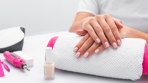 Front view woman getting her manicure done at the salon