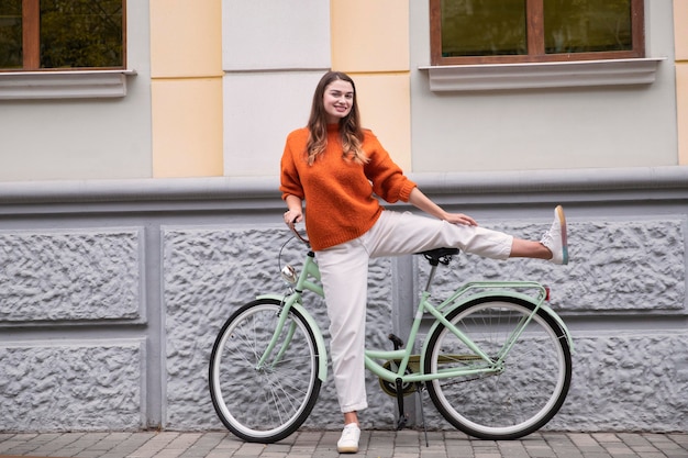 Front view of woman posing silly with her bicycle outdoors