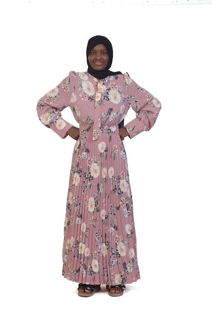 Front view of a woman standing arms akimbo and dress and burka over white background