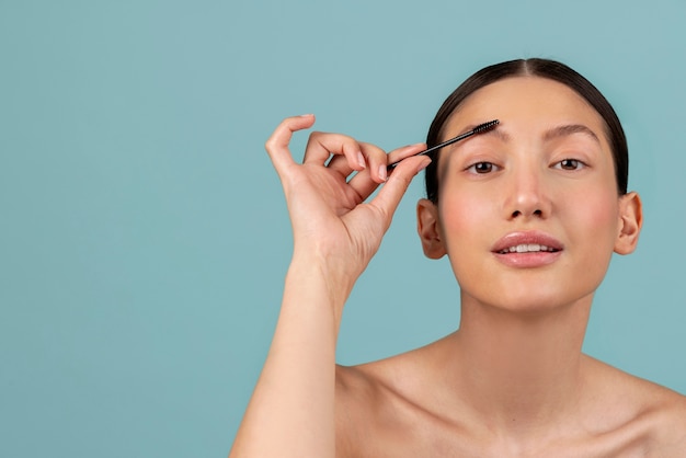 Front view woman using brow brush