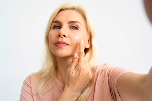 Front view woman using face cream