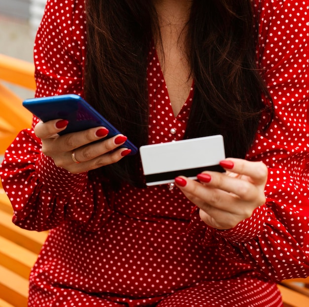 Front view of woman using smartphone and credit card to shop sales online