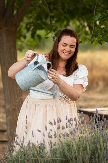 Photo front view woman watering flowers