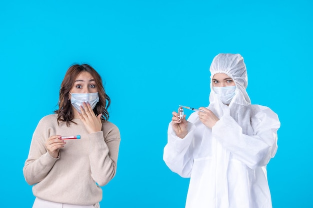 front view young female doctor in protective suit with patient on a blue background science disease medical covid- pandemic health isolation virus