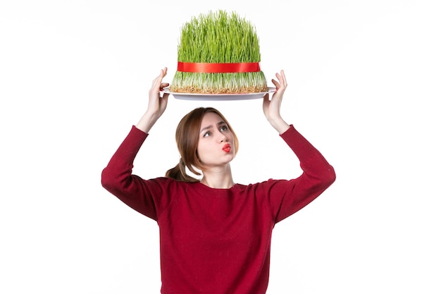 front view young female holding big green novruz semeni on her head on white background spring ethnic performer concept holiday family ethnicity