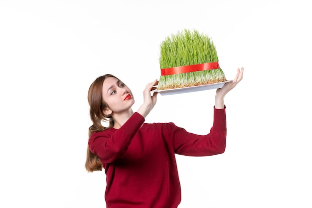 front view young female holding big green novruz semeni on white background spring ethnic performer concept colours holidays family ethnicity