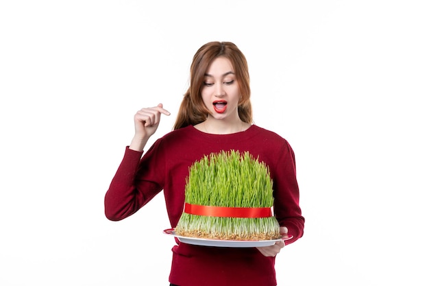 front view young female holding big green novruz semeni on white background spring ethnic performer ethnicity family colours holiday