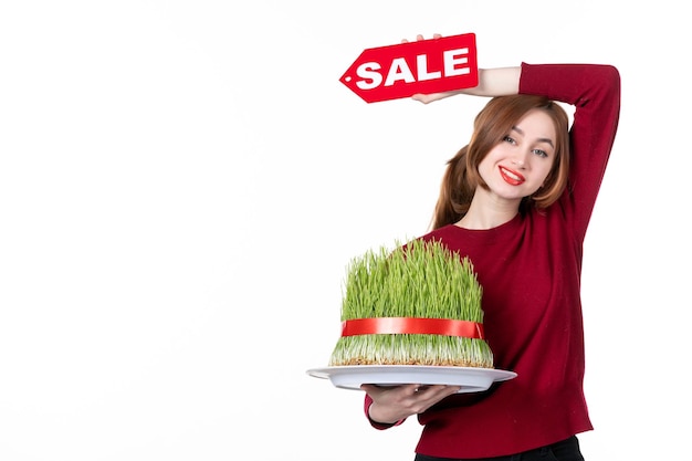 front view young female holding big novruz semeni and sale nameplate on white background diner colours performer ethnicity concept shopping spring