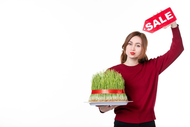 front view young female holding big novruz semeni and sale nameplate on white background diner colours performer ethnicity concept spring ethnic