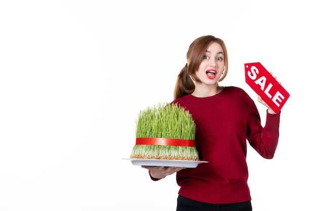 front view young female holding big novruz semeni and sale nameplate on white background diner colours performer ethnicity shopping spring ethnic