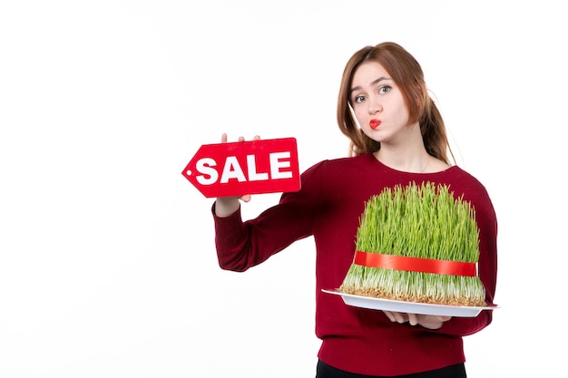 front view young female holding big novruz semeni and sale nameplate on white background spring colours ethnicity shopping family ethnic concept performers