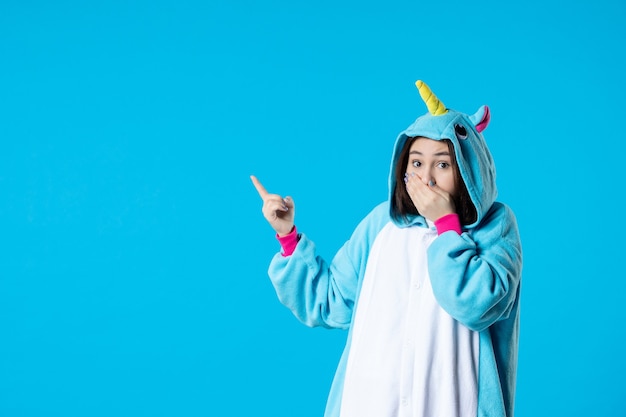 front view young female in kigurumi for pajama party on blue background rest cartoon sleep color late fun night friends anime bed game