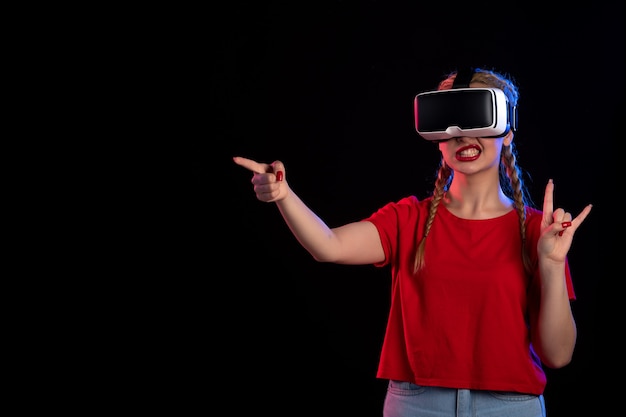 Front view of young female playing vr on dark  game ultrasound fantasy