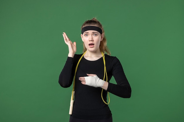 Front view young female with bandage around her hurt arm on green background athlete pain health injury woman workout body color