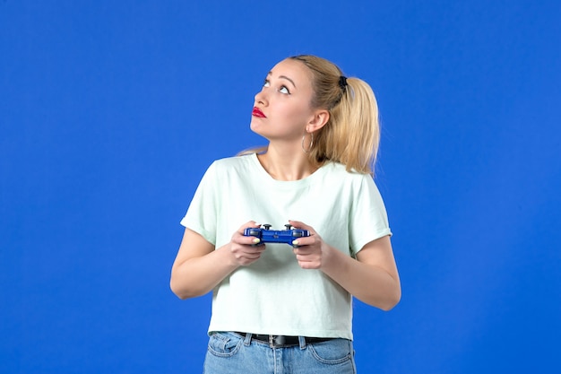 front view young female with gamepad on blue background online virtual joy players adult youth joyful winning video joystick