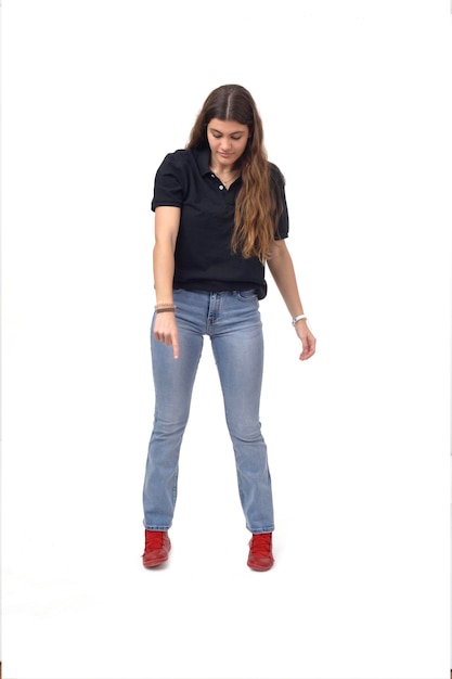 Front view of a young girl pointing down on white background