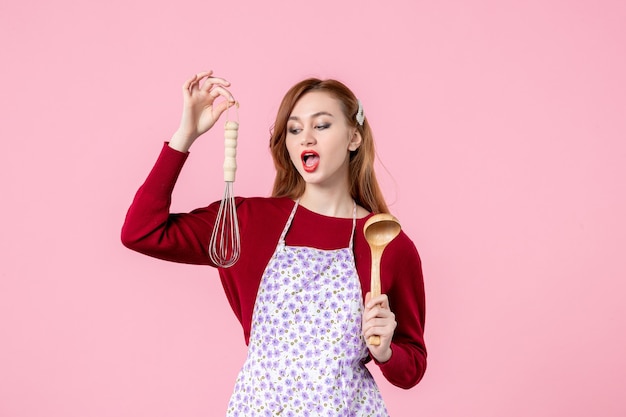 front view young housewife holding whisk and wooden spoon on pink background kitchen pie woman shopping money cuisine food cake