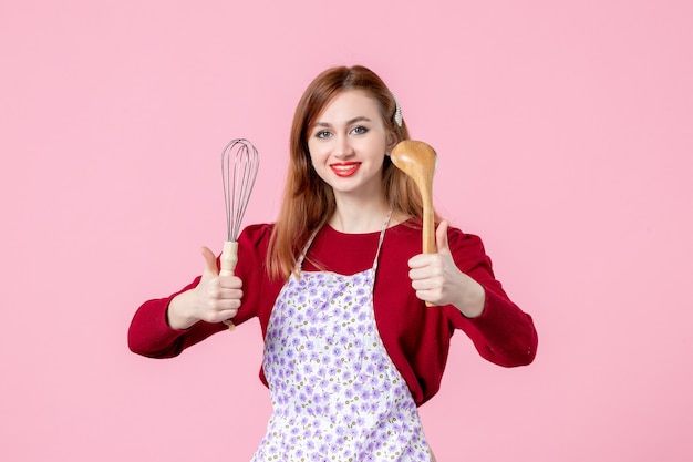 front view young housewife posing with whisk and wooden spoon on pink background cake profession cooking dough woman cuisine horizontal pie