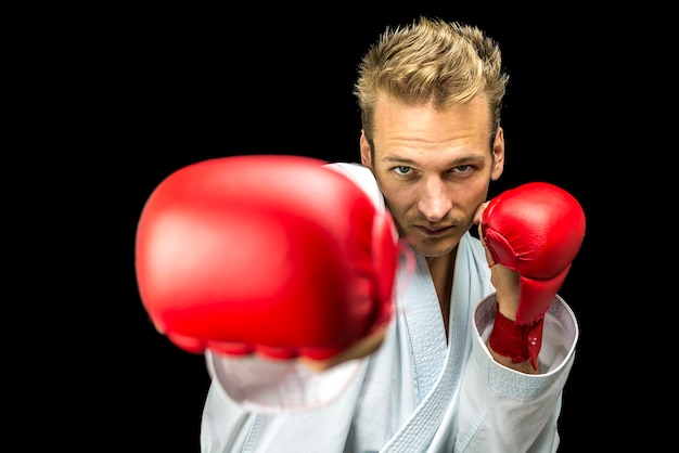 Front view of young kick boxer fighter isolated  over black background.