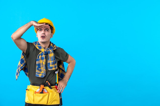 front view young male builder with yellow helmet on blue background constructor architecture building color tool flat worker