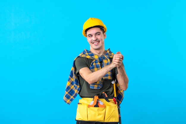 front view young male builder in yellow helmet on blue background color flat constructor architecture building worker