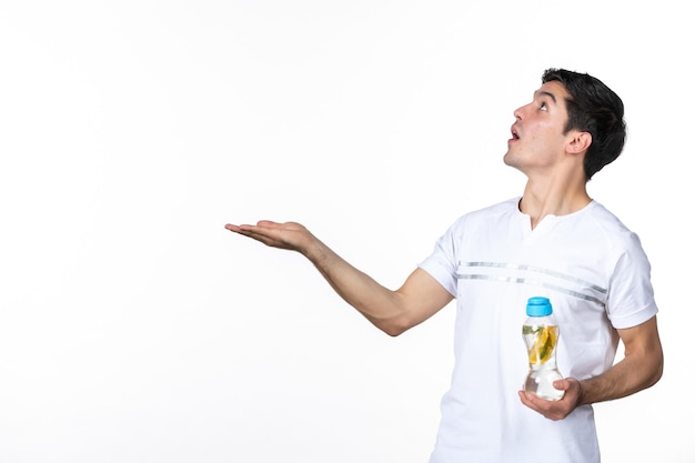 Front view young male holding bottle of lemonade on white