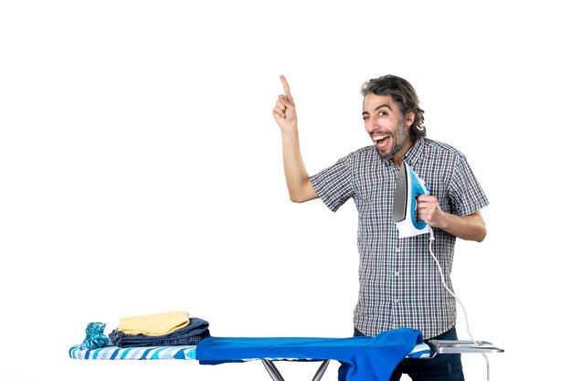 front view young male holding iron on white background ironing color housework clean clothes man home