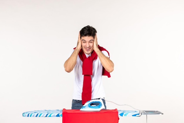 Front view young male ironing towel and laughing on white background clean housework home work fashion man