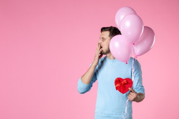 front view young male with cute pink balloons and heart shaped present on pink background equality womens day marriage march sensual feminine love park date