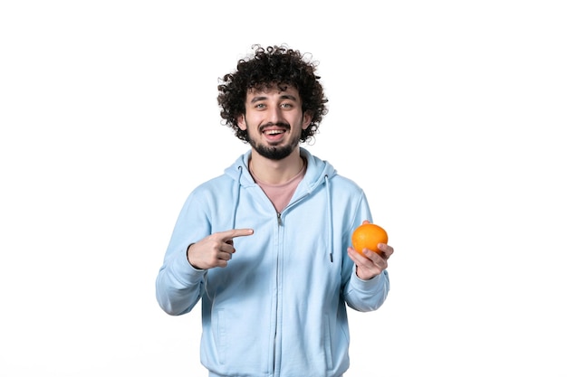 Front view young man with fresh orange on white surface