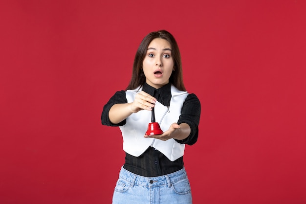 front view young waitress in uniform holding little bell on red background dinner evening work job cafe worker restaurant dish colors