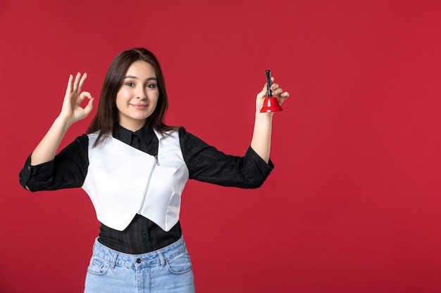 front view young waitress in uniform holding little bell on red desk woman dinner work evening worker beauty job restaurant