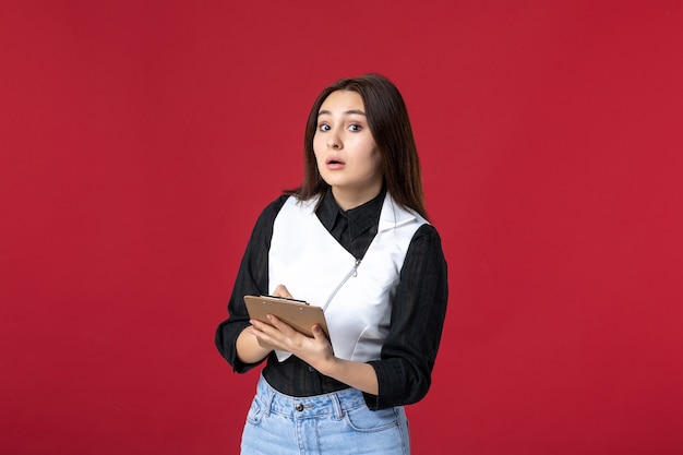 front view young waitress in uniform writing order on red background beauty woman dinner evening job restaurant worker