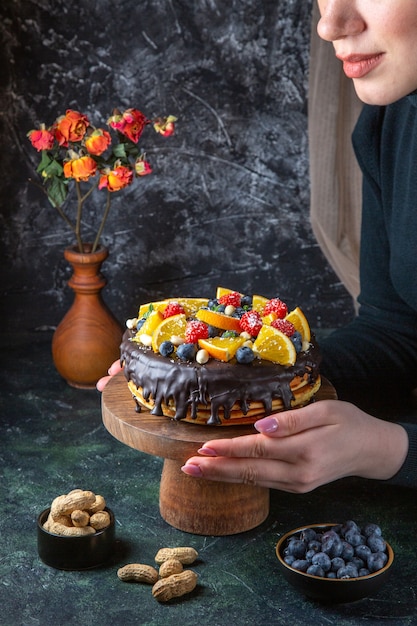 Front view yummy chocolate cake with fresh fruits on dark wall