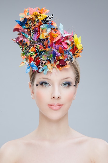 Frontal portrait of a beautiful girl wearing on the top of her head a bouquet of flowers