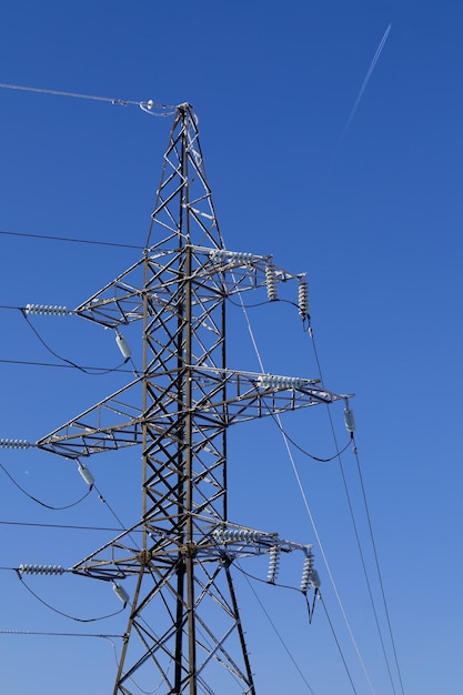 Frostcovered power line pylon on a clear frosty day against a blue sky