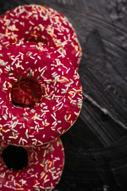 Frosted sprinkled donuts sweet pastry dessert on rustic wooden background doughnuts as tasty snack top view food brand flat lay for blog menu or cookbook design