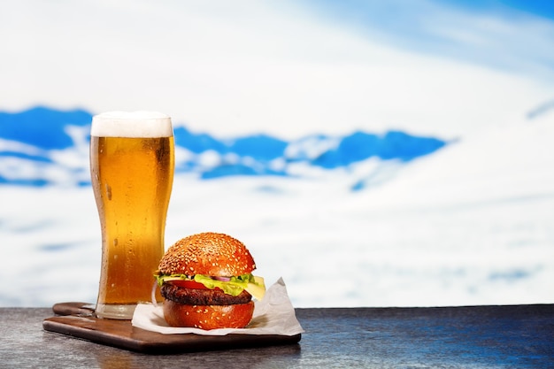 Frosty glass of light beer with hamburger