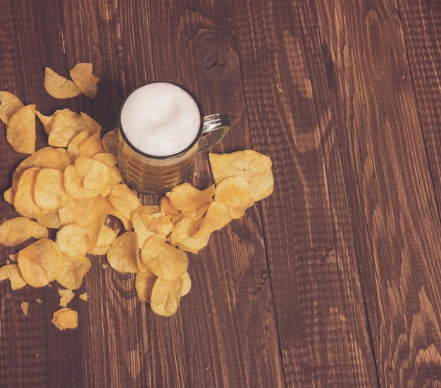 The frothy beer with crunchy chips on the table