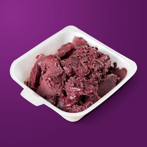 Frozen acai berry on a styrofoam lunch box isolated on purple background