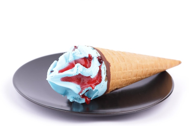 Frozen blue and red dessert Ice cream in a waffle cone on a black plate closeup Ice cream cone isolated on white background