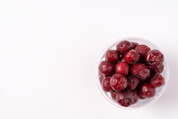 Frozen cherry in plastic box isolated on white background,flat lay.