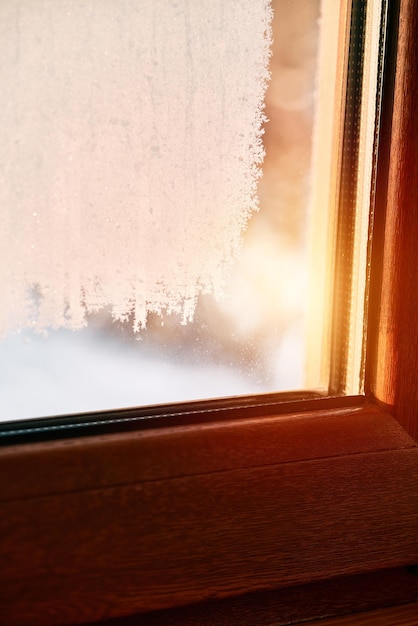 Frozen condensation on the interior window glass Iced steam and dew on the glass during winter