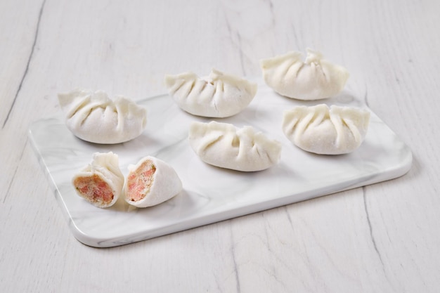 Frozen dumplings stuffed with liver and provencal herbs on marble serving plate