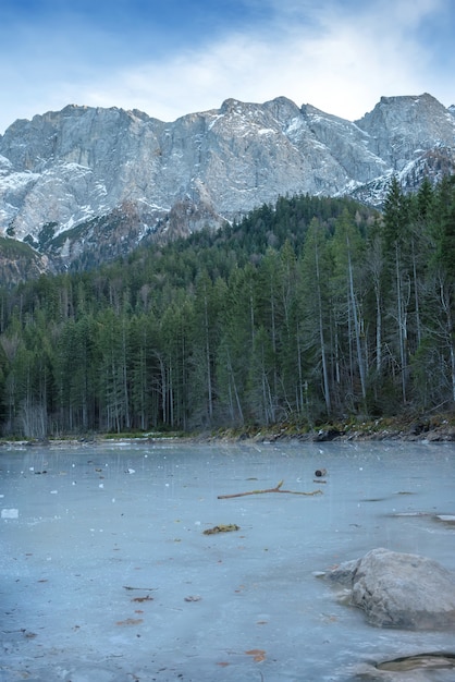 Frozen forest lake in Bavarian Alps near Eibsee lake, winter.