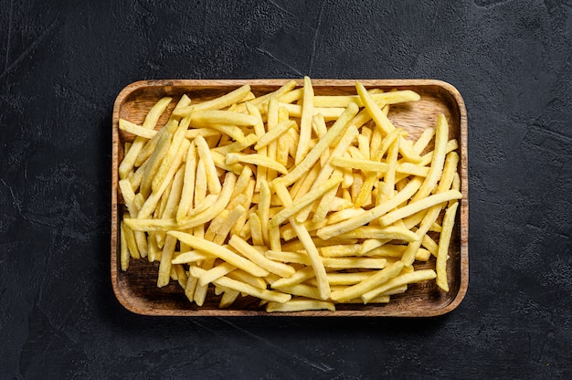 Frozen French fries in a wooden bowl.