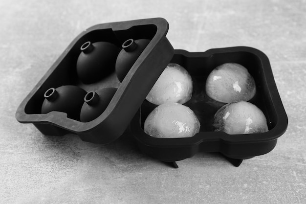 Frozen ice balls in mold on grey table