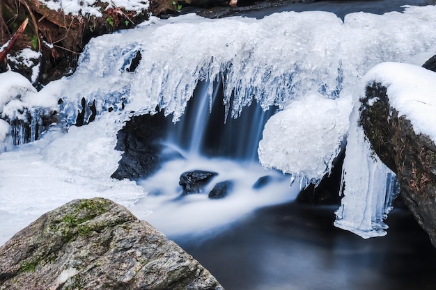 Frozen little waterfall in the nature during hiking