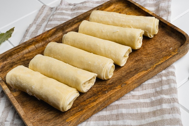 Frozen pancakes with meat on white ceramic squared tile table background