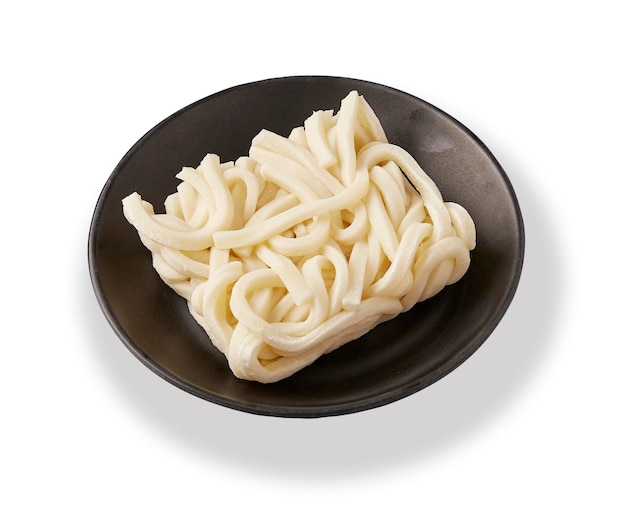 Frozen ramen noodle are placed on a black plate isolated on white background